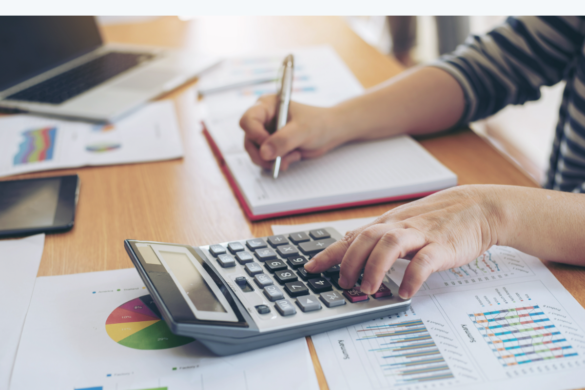 Contable calculando impuestos con calculadora y documentos