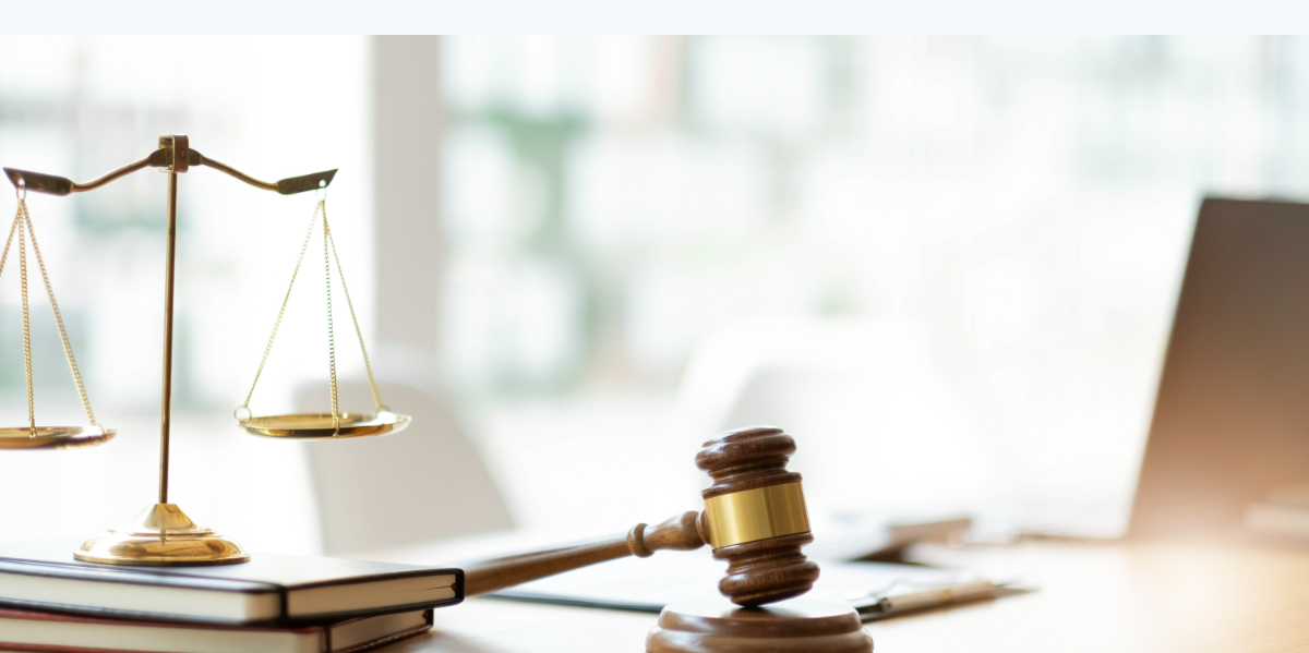 Balanza de la justicia y mazo sobre mesa de despacho legal